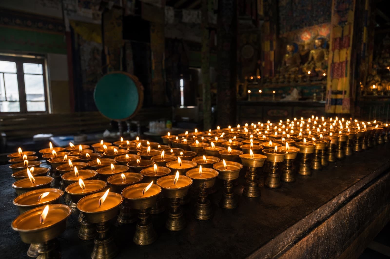 Butter lamps glowing inside a temple
